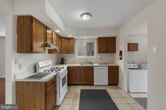 a kitchen with a sink stove top oven and cabinets
