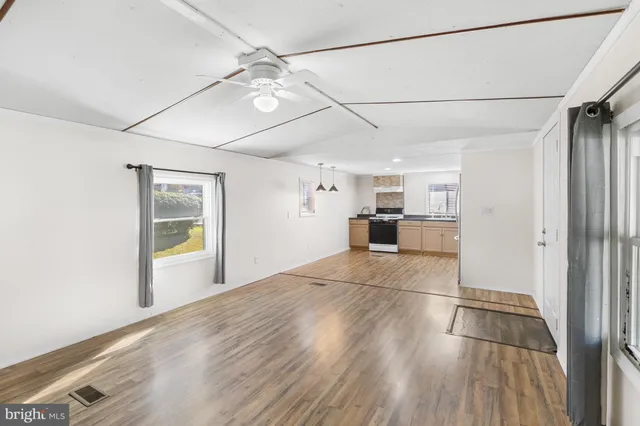 a view of empty room with wooden floor and window