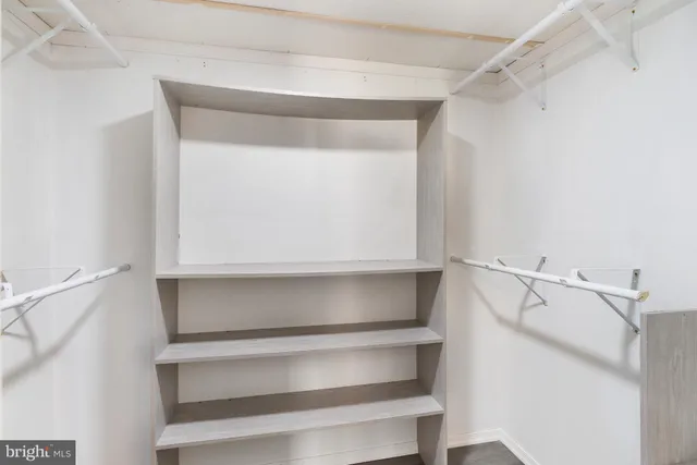 a view of walk in closet with empty racks