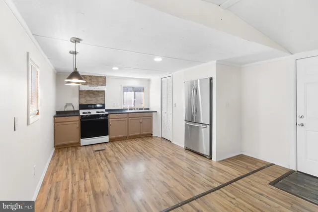 a kitchen with a refrigerator and white cabinets