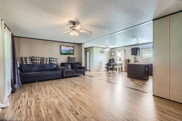 a living room with furniture and a wooden floor