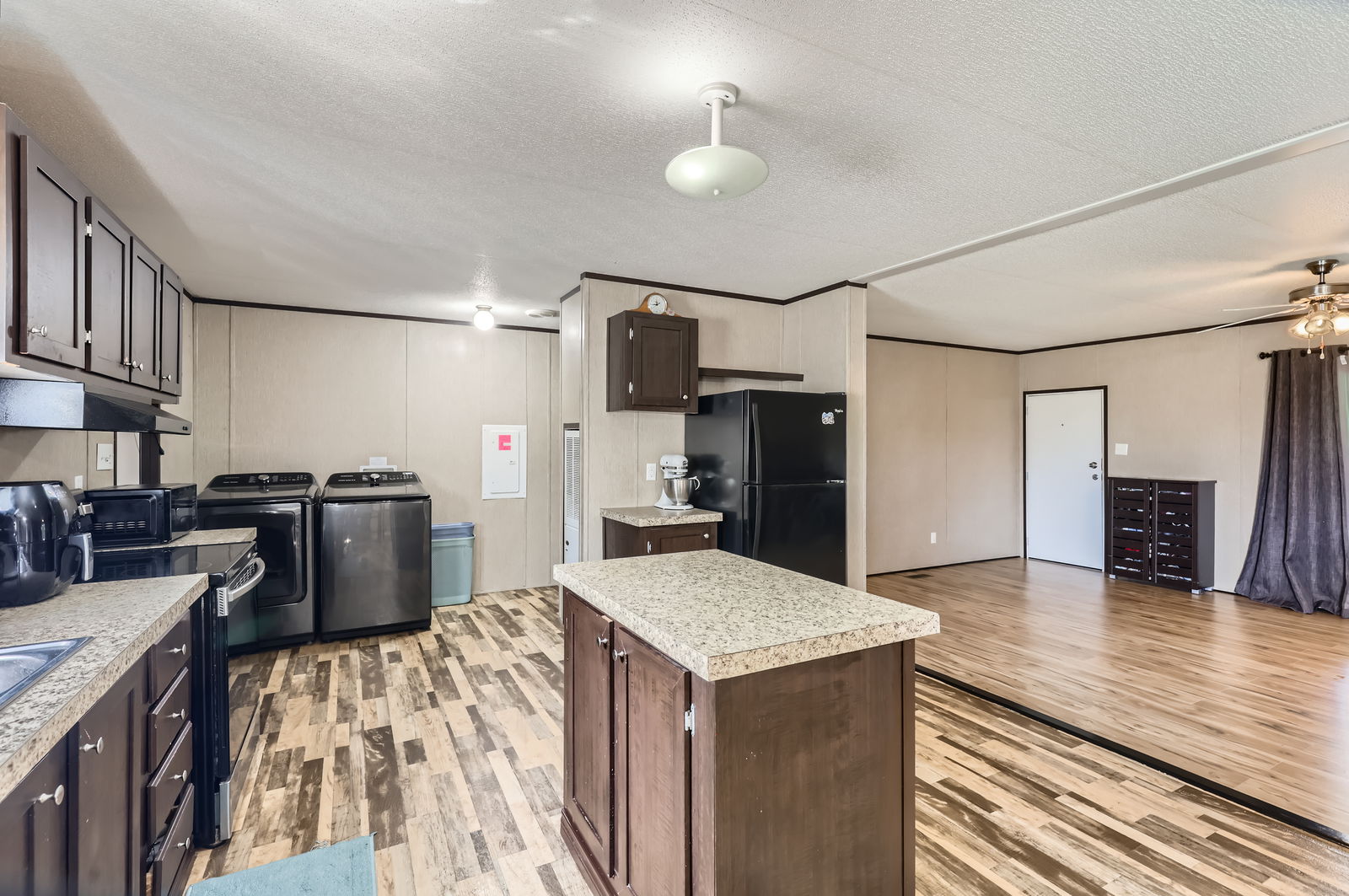 415 County Road 154 Georgetown, TX 78626 - Photo 18 of 28 Kitchen featuring freestanding refrigerator, washer and clothes dryer, light wood-type flooring, light countertops, and a textured ceiling