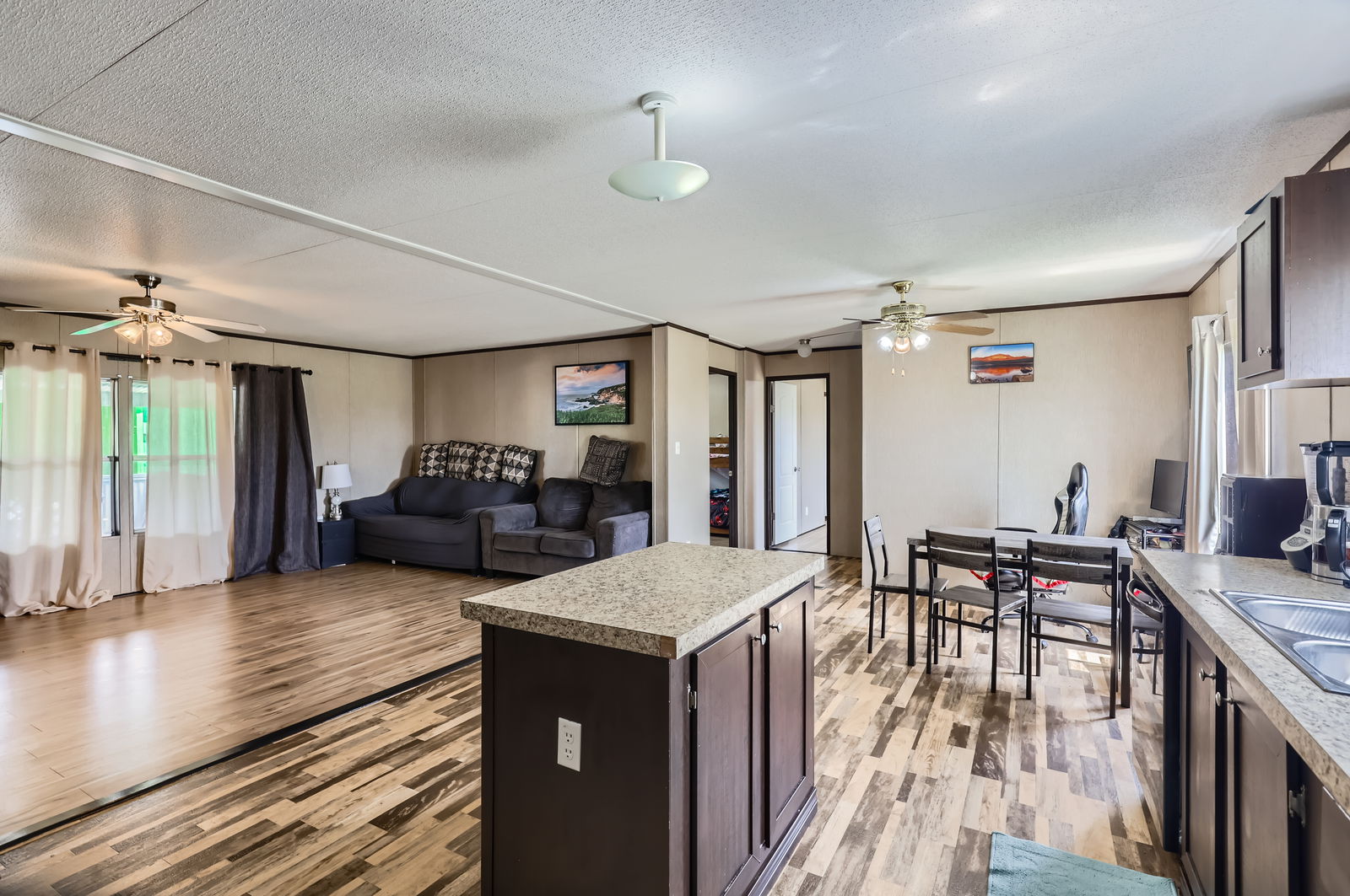 415 County Road 154 Georgetown, TX 78626 - Photo 28 of 28 Kitchen with ceiling fan, a textured ceiling, light wood-type flooring, light countertops, and open floor plan