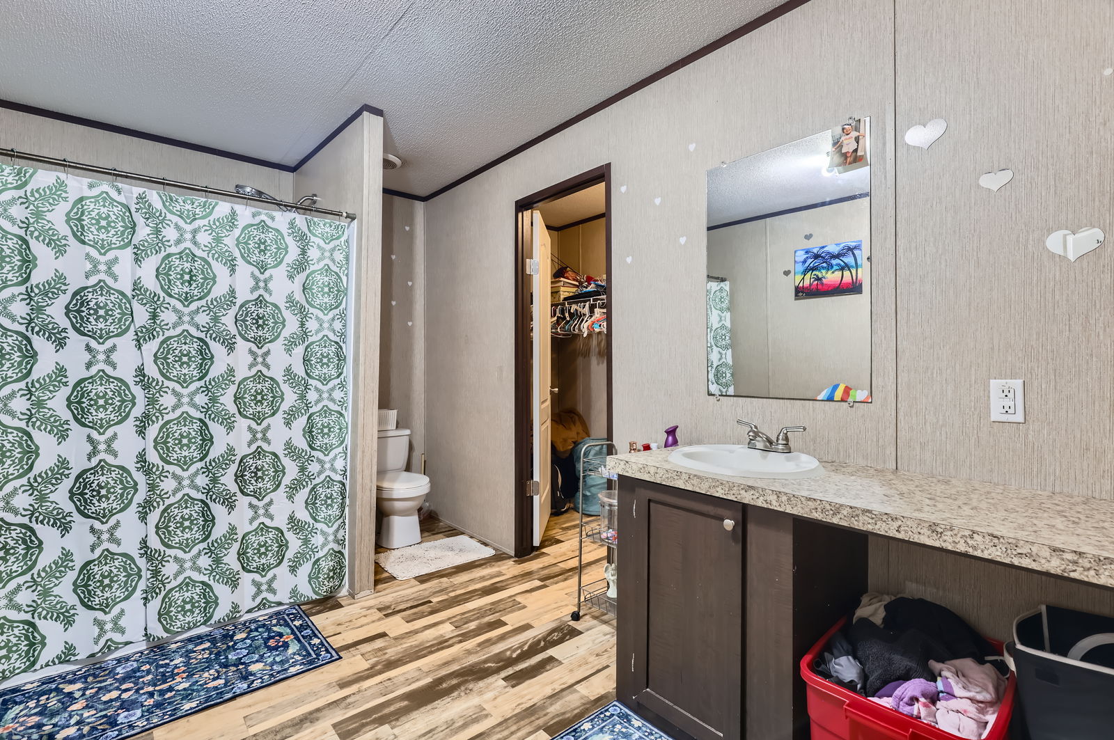 415 County Road 154 Georgetown, TX 78626 - Photo 19 of 28 Full bathroom featuring wood finished floors, vanity, ornamental molding, curtained shower, and a textured ceiling