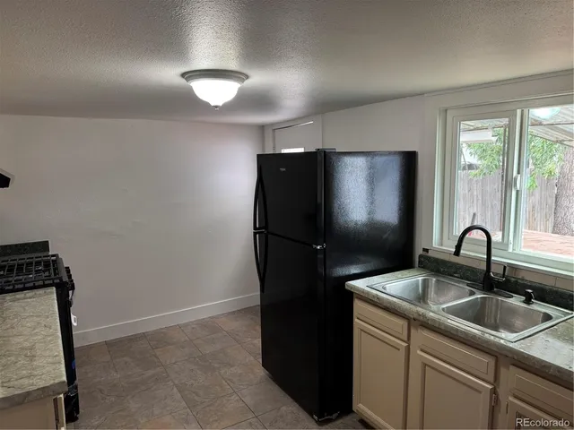 a kitchen with granite countertop a stove and a refrigerator