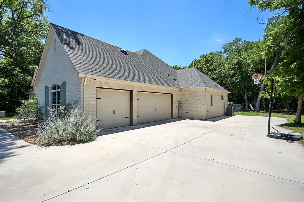 358 Glade Valley Road Azle, TX 76020 - Photo 35 of 35 Expansive concrete driveway servicing a two-car garage with carriage-style doors