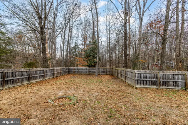 a view of a house with wooden fence next to a road