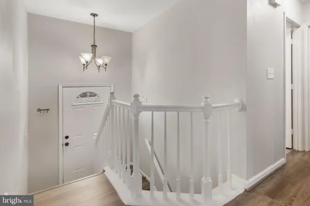 a view of a hallway with chandelier and stairs