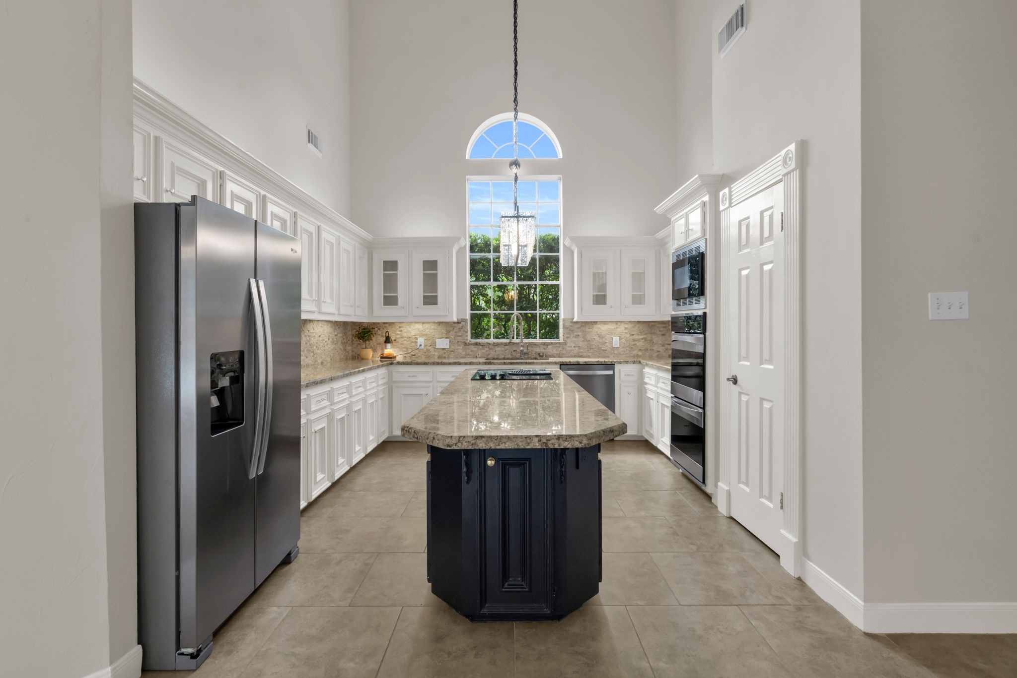 17302 Chagall Lane Spring, TX 77379 - Photo 11 of 44 The architect-designed kitchen is a breathtaking centerpiece, featuring soaring ceilings, an oversized arched window that floods the space with natural light