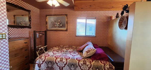 a bedroom with a bed and a painting on the wall