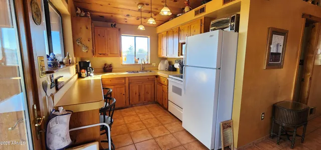 a living room with furniture and a refrigerator