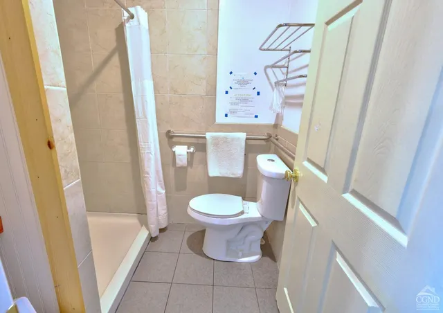 a view of a park with large trees and wooden fence