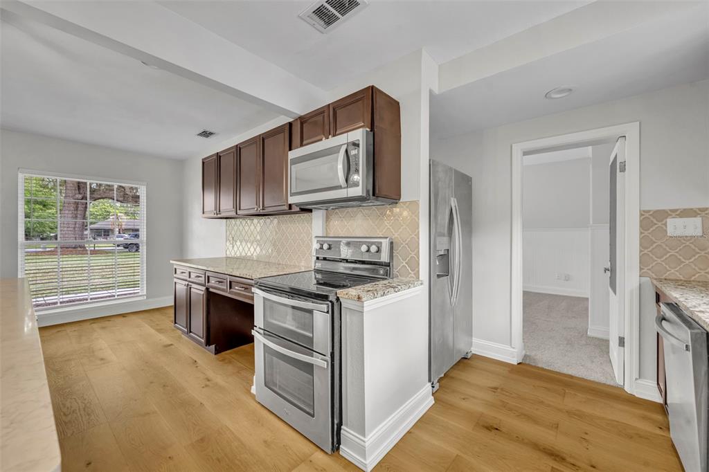 4234 Kendrick Road Orlando, FL 32804 - Photo 15 of 46 a kitchen with stainless steel appliances granite countertop a stove a sink and a refrigerator