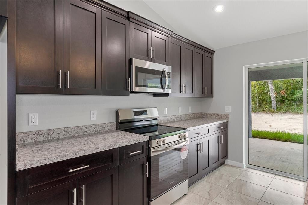 79 Daisy Street Homosassa, FL 34446 - Photo 11 of 36 a kitchen with granite countertop cabinets stainless steel appliances and a counter space