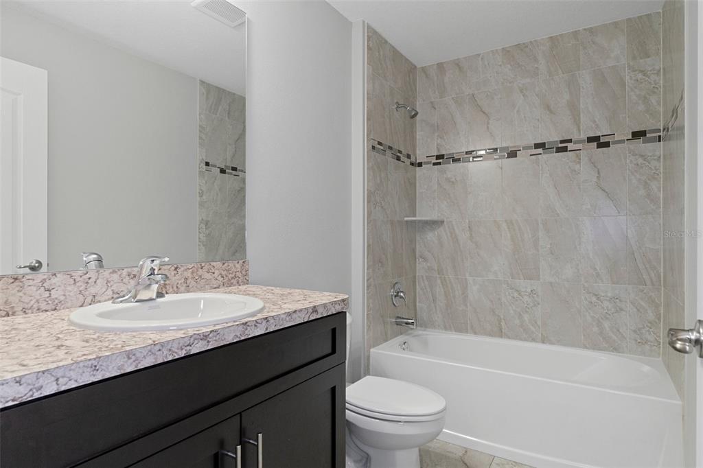 79 Daisy Street Homosassa, FL 34446 - Photo 33 of 36 a bathroom with a granite countertop sink toilet and shower