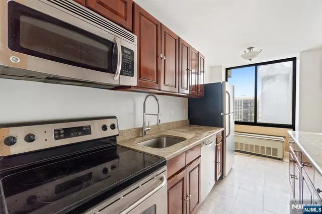 a kitchen with stainless steel appliances granite countertop a stove microwave and refrigerator