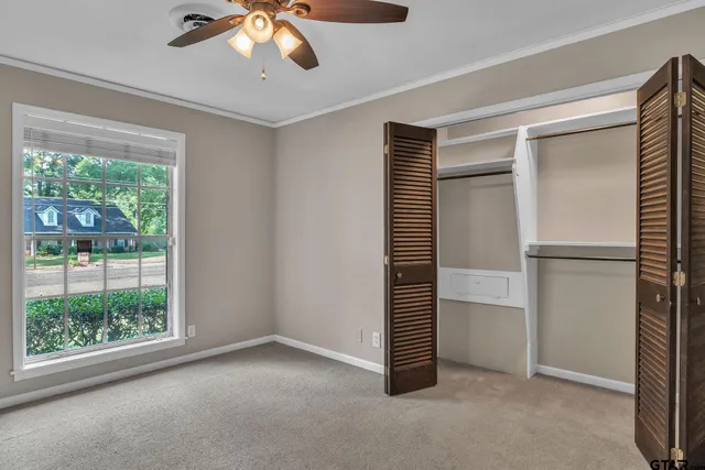 a view of empty room with window and ceiling fan
