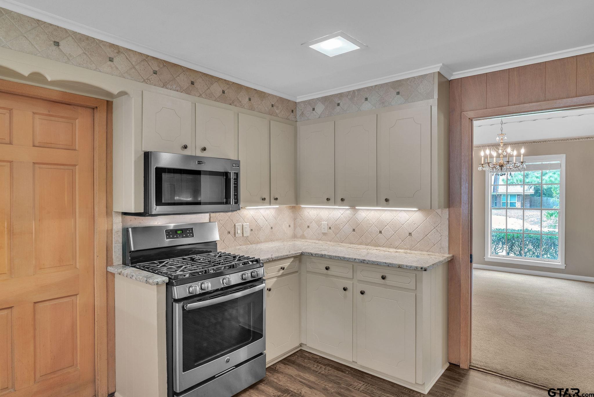 700 Emily Drive Longview, TX 75601 - Photo 33 of 45 a kitchen with stainless steel appliances granite countertop a stove and a microwave