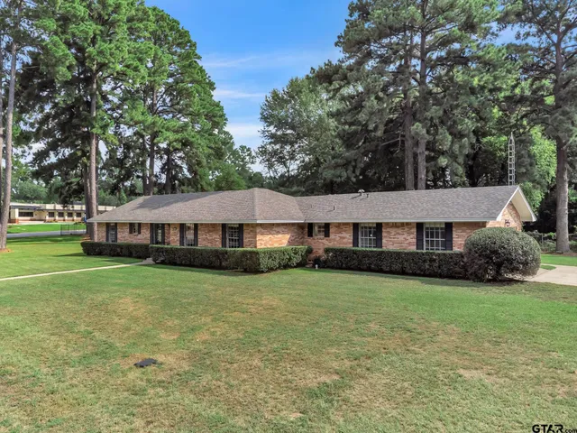 a view of a house with a big yard and large trees