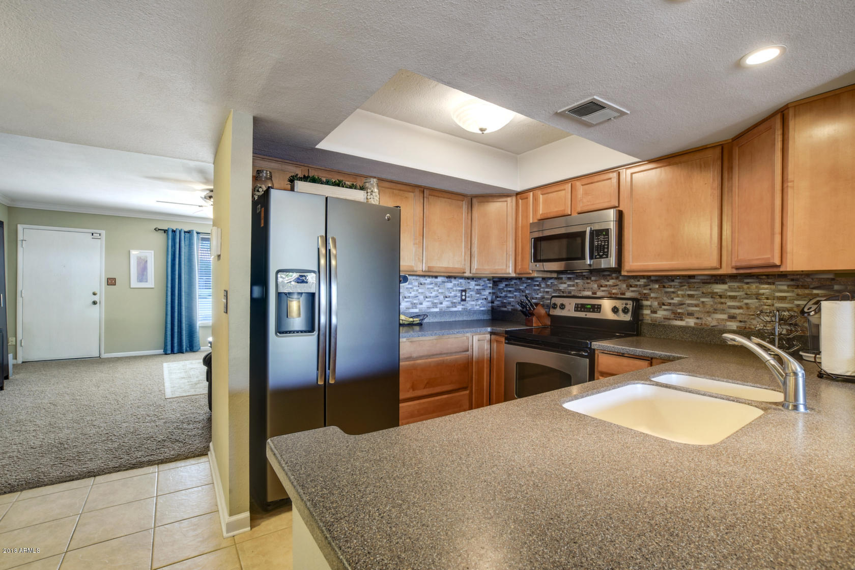 5910 North Granite Reef Road Scottsdale, AZ 85250 - Photo 5 of 33 a kitchen with stainless steel appliances granite countertop a refrigerator a stove top oven and a sink