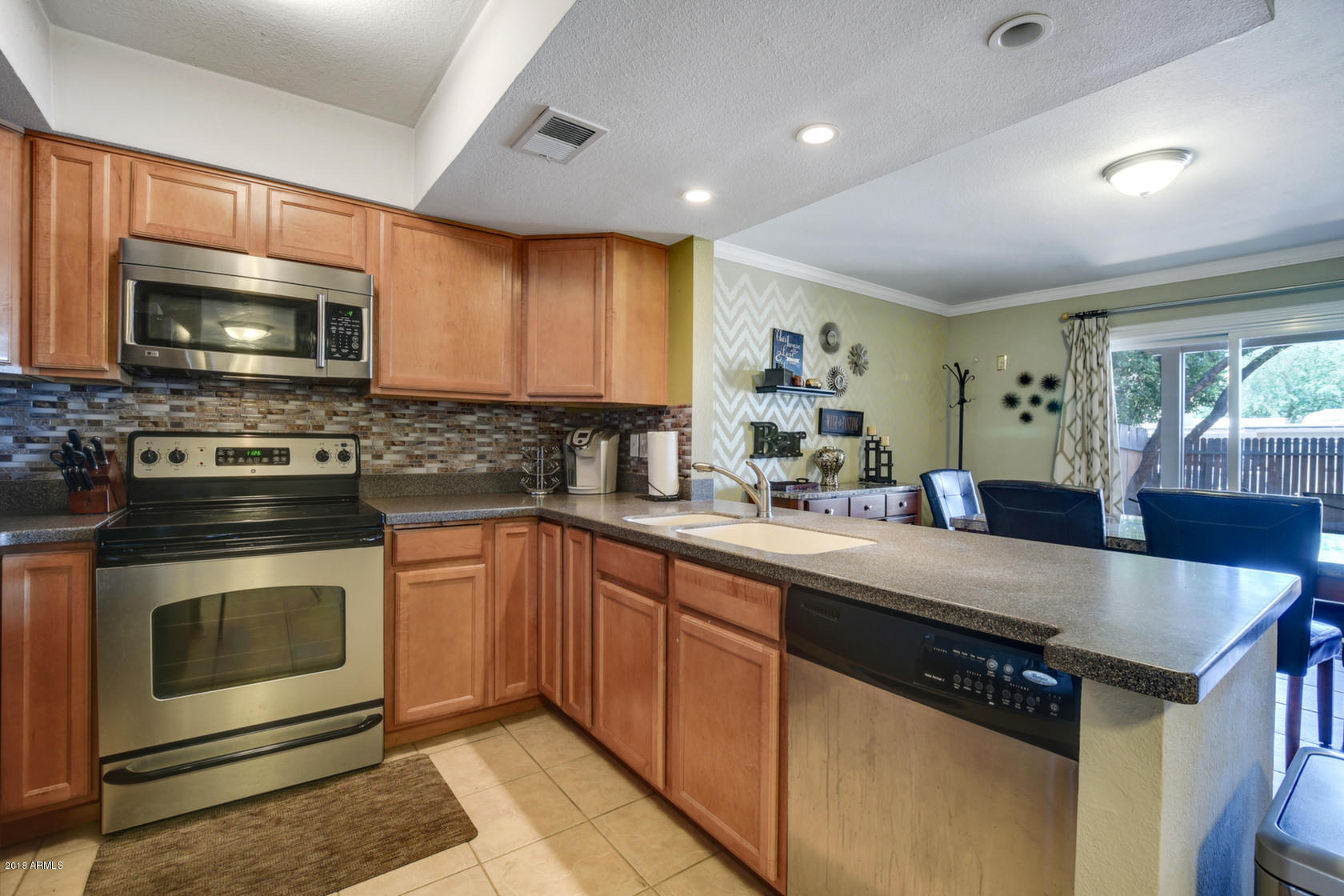 5910 North Granite Reef Road Scottsdale, AZ 85250 - Photo 10 of 33 a kitchen with stainless steel appliances granite countertop a stove a sink and a microwave
