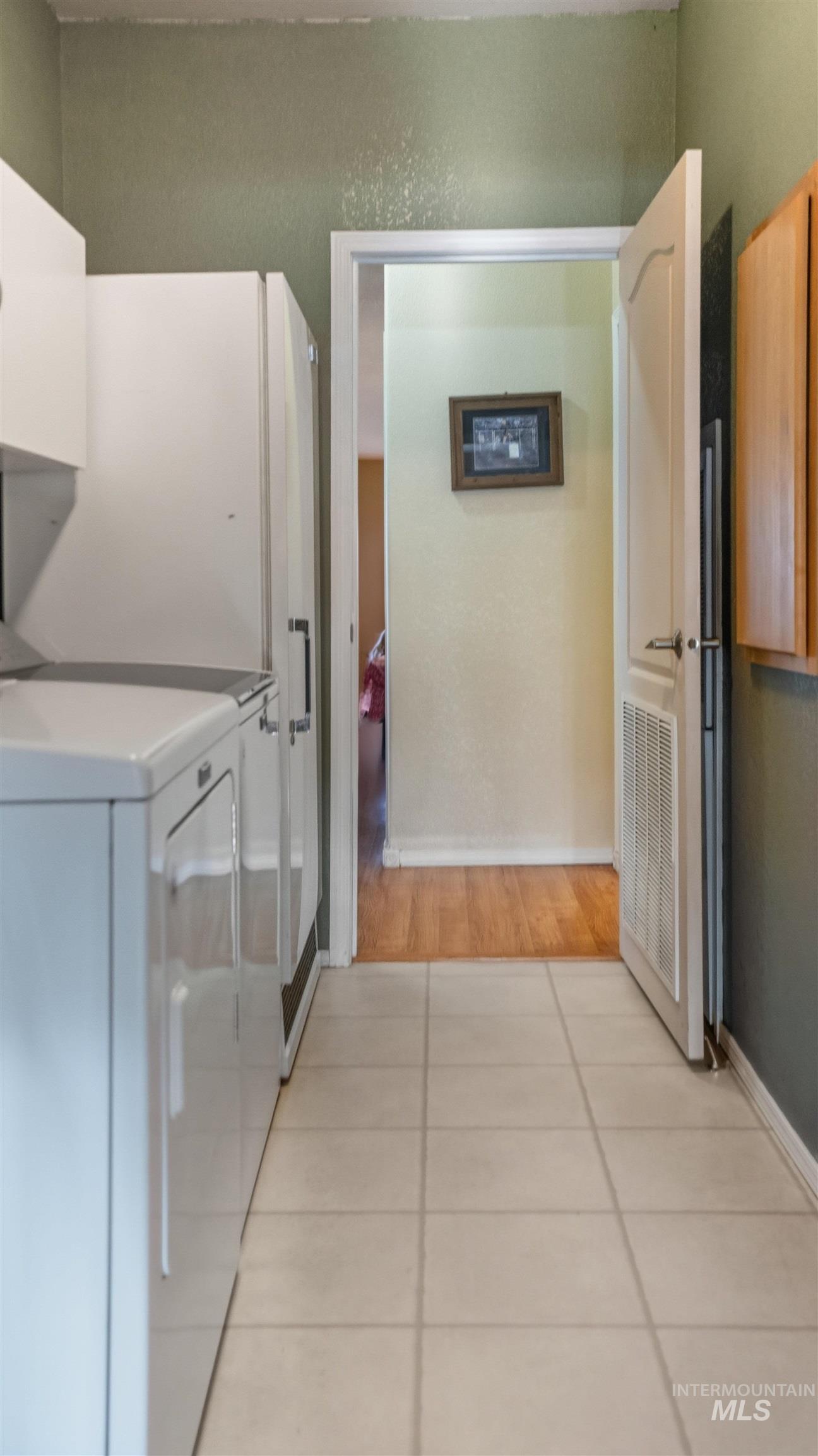 19397 Cloverland Road Asotin, WA 99402 - Photo 21 of 37 Laundry room featuring light tile patterned floors, washing machine and dryer, and cabinet space