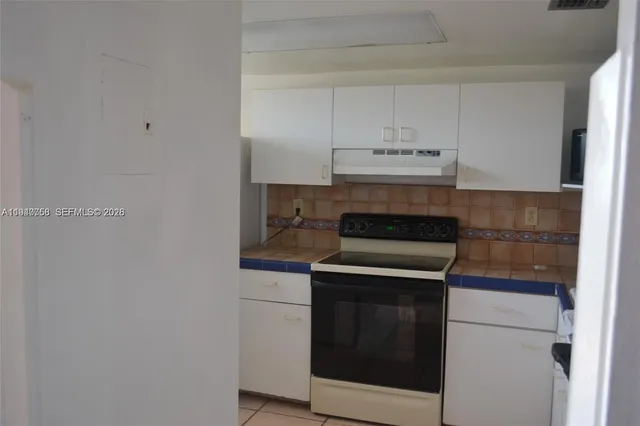 a stove top oven sitting inside of a kitchen