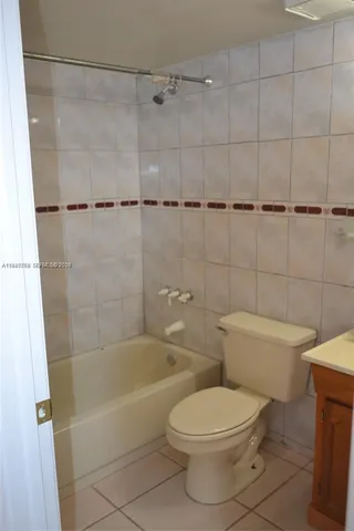 a white toilet sitting next to a bath tub and shower