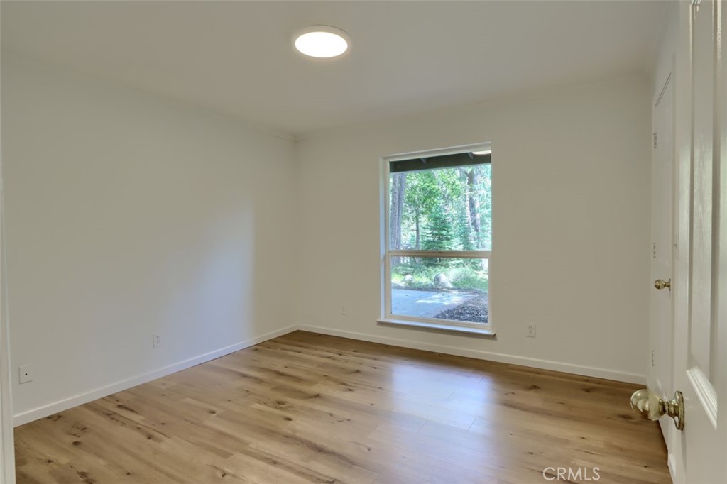 7174 Hites Cove Road Mariposa, CA 95338 - Photo 32 of 62 an empty room with wooden floor and windows
