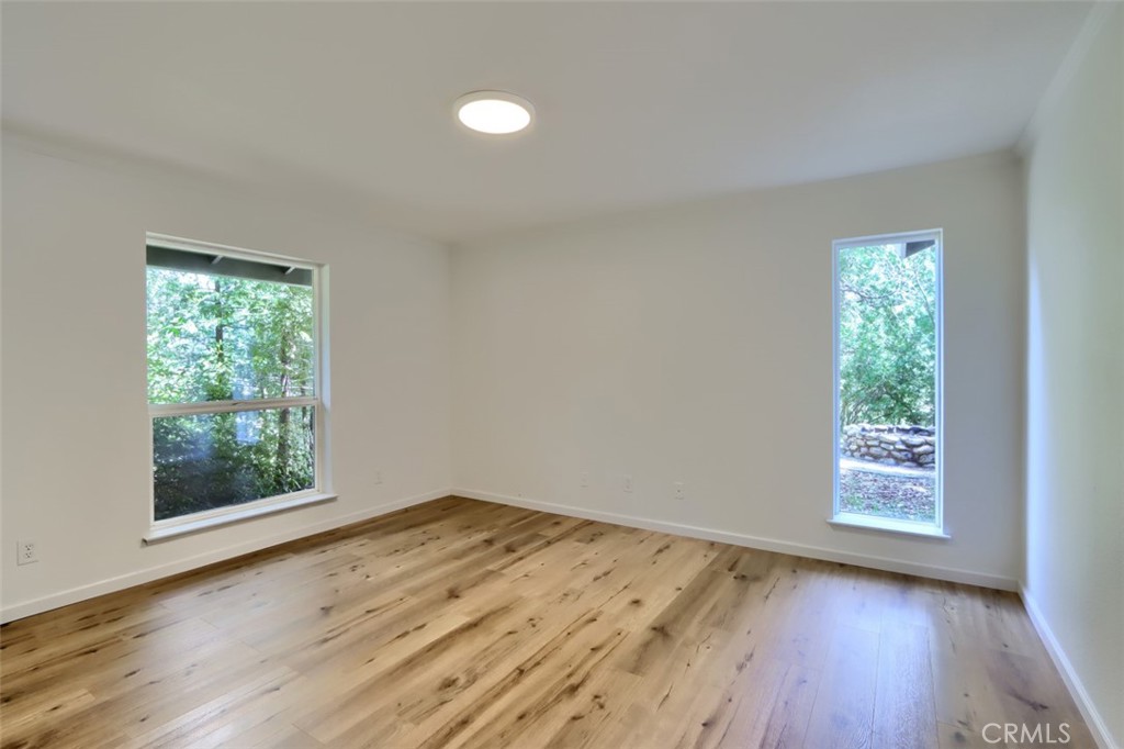 7174 Hites Cove Road Mariposa, CA 95338 - Photo 37 of 62 an empty room with wooden floor and windows