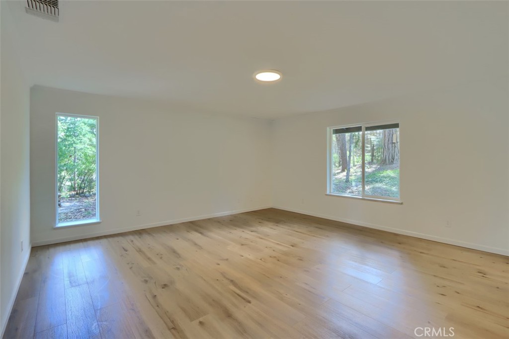 7174 Hites Cove Road Mariposa, CA 95338 - Photo 40 of 62 an empty room with wooden floor and windows