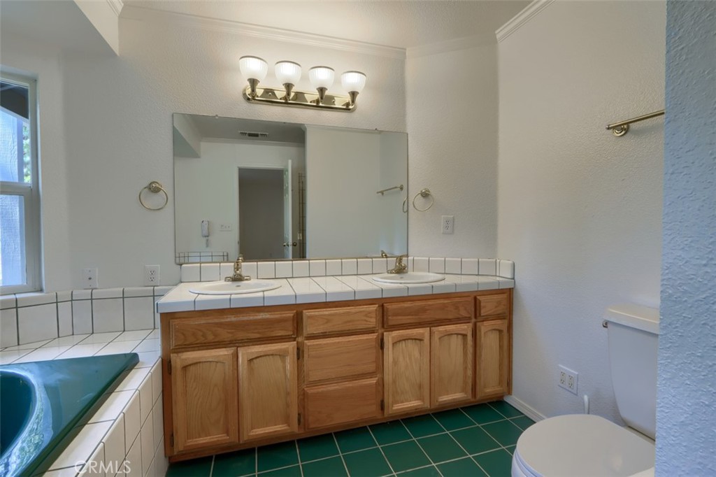 7174 Hites Cove Road Mariposa, CA 95338 - Photo 43 of 62 a bathroom with a granite countertop toilet a sink and a mirror