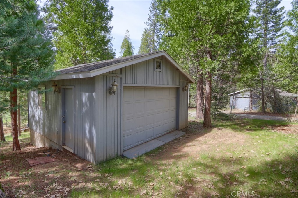 7174 Hites Cove Road Mariposa, CA 95338 - Photo 57 of 62 a view of a small house with wooden fence and large trees