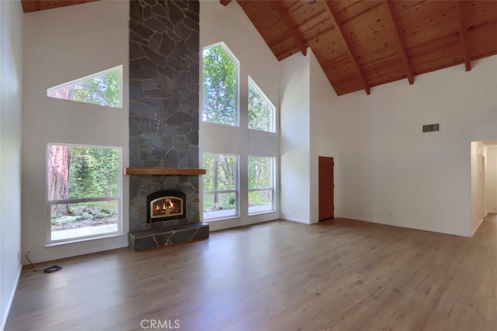7174 Hites Cove Road Mariposa, CA 95338 - Photo 9 of 62 an empty room with windows fire place and a fireplace