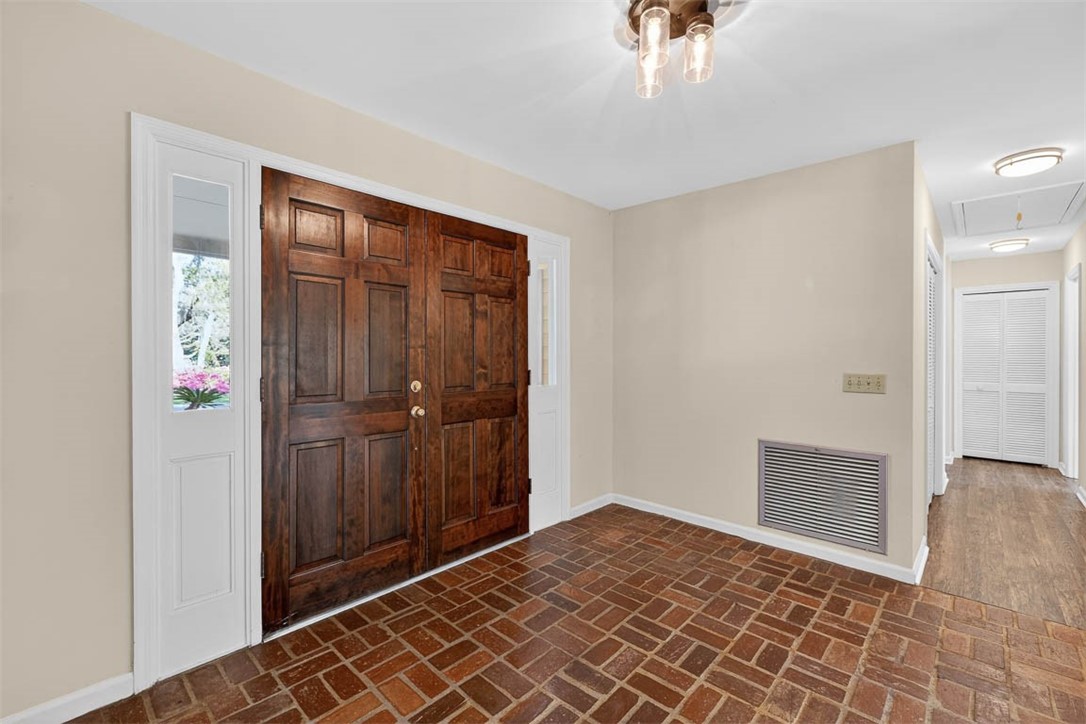 201 Five Pounds Road St. Simons Island, GA 31522 - Photo 2 of 37 Foyer has real French doors and brick paver flooring that extends down the hall to the kitchen