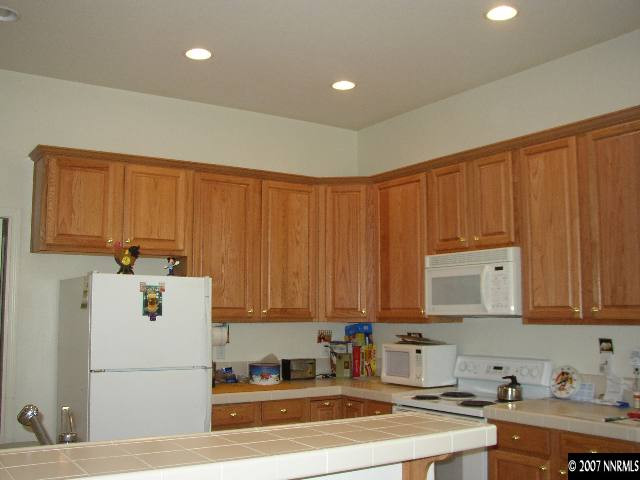 487 Sierra Leaf Circle Reno, NV 89511 - Photo 6 of 9 a kitchen with a refrigerator a sink and cabinets
