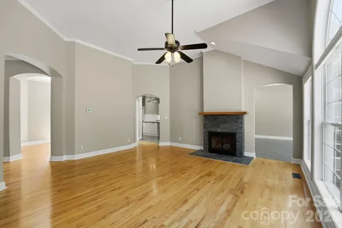 a view of empty room with fireplace and wooden floor