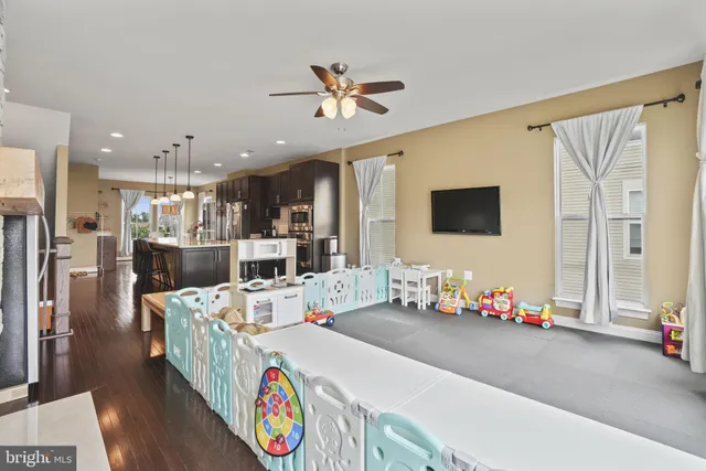 a living room with furniture kitchen view and a large window