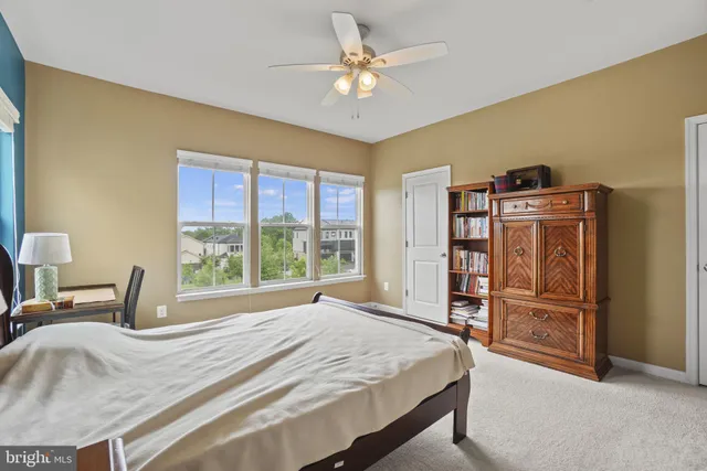 a bedroom with a bed and a large window with the outer view