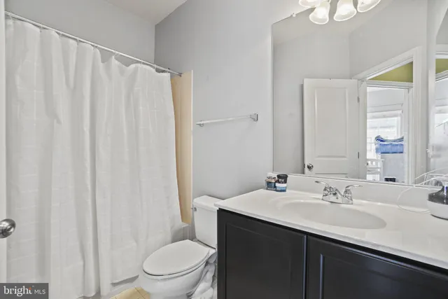 a bathroom with a sink a toilet and shower curtain