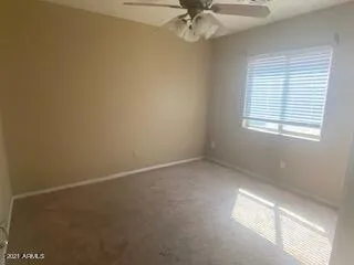 an empty room with a ceiling fan and a window