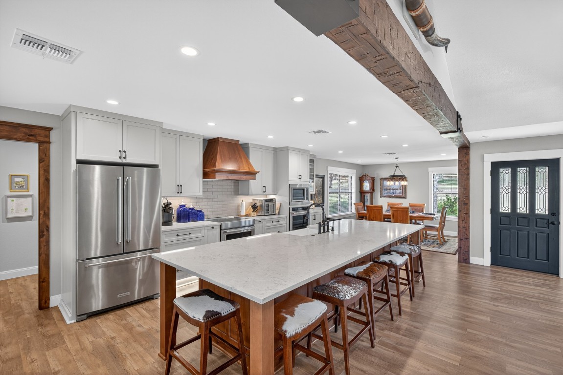 23642-23644 Nameless Road Leander, TX 78641 - Photo 25 of 37 a kitchen with stainless steel appliances a dining table chairs refrigerator sink and cabinets