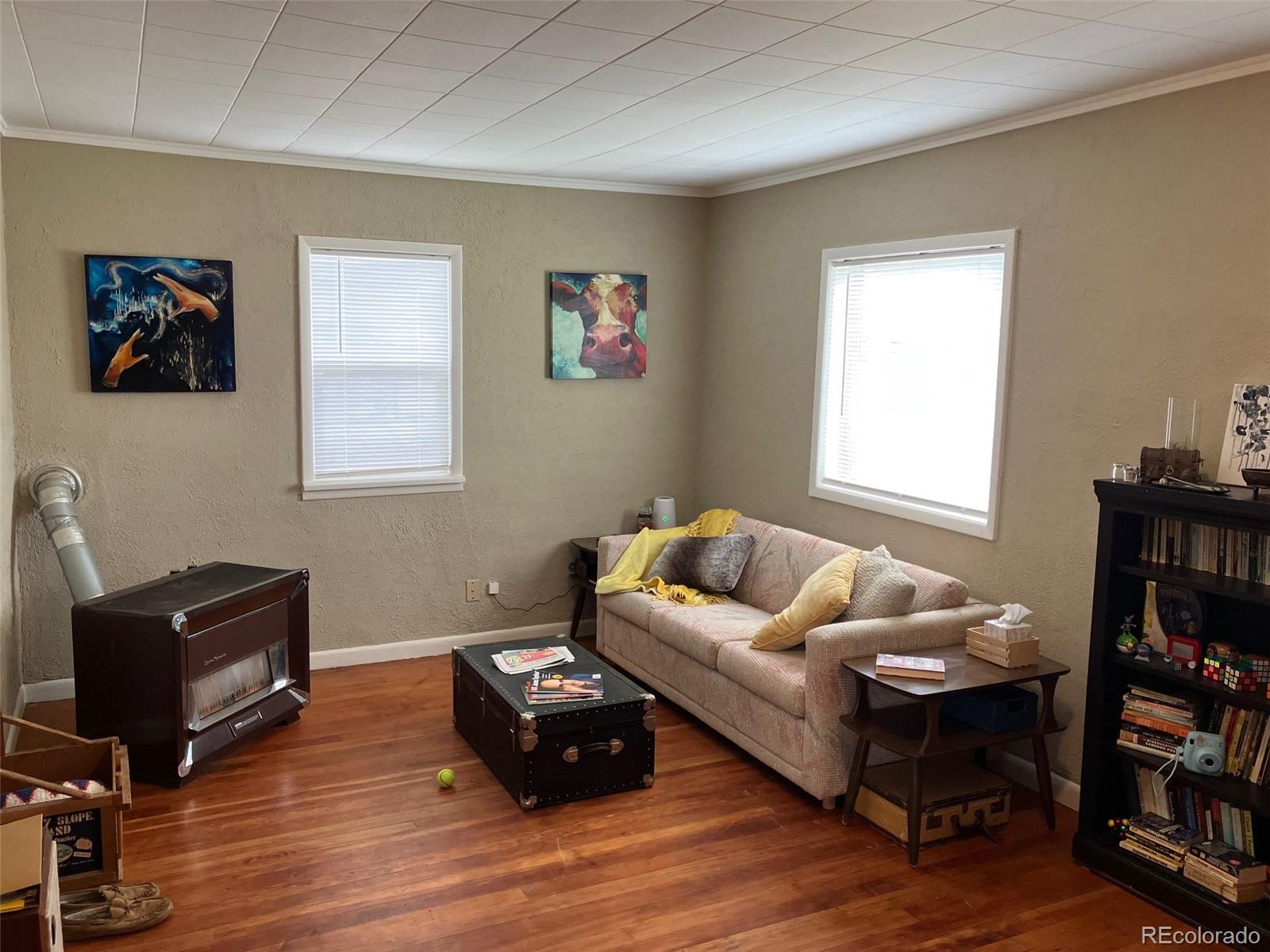 321 Jefferson Street Sterling, CO 80751 - Photo 2 of 10 a living room with furniture a bookshelf and a window