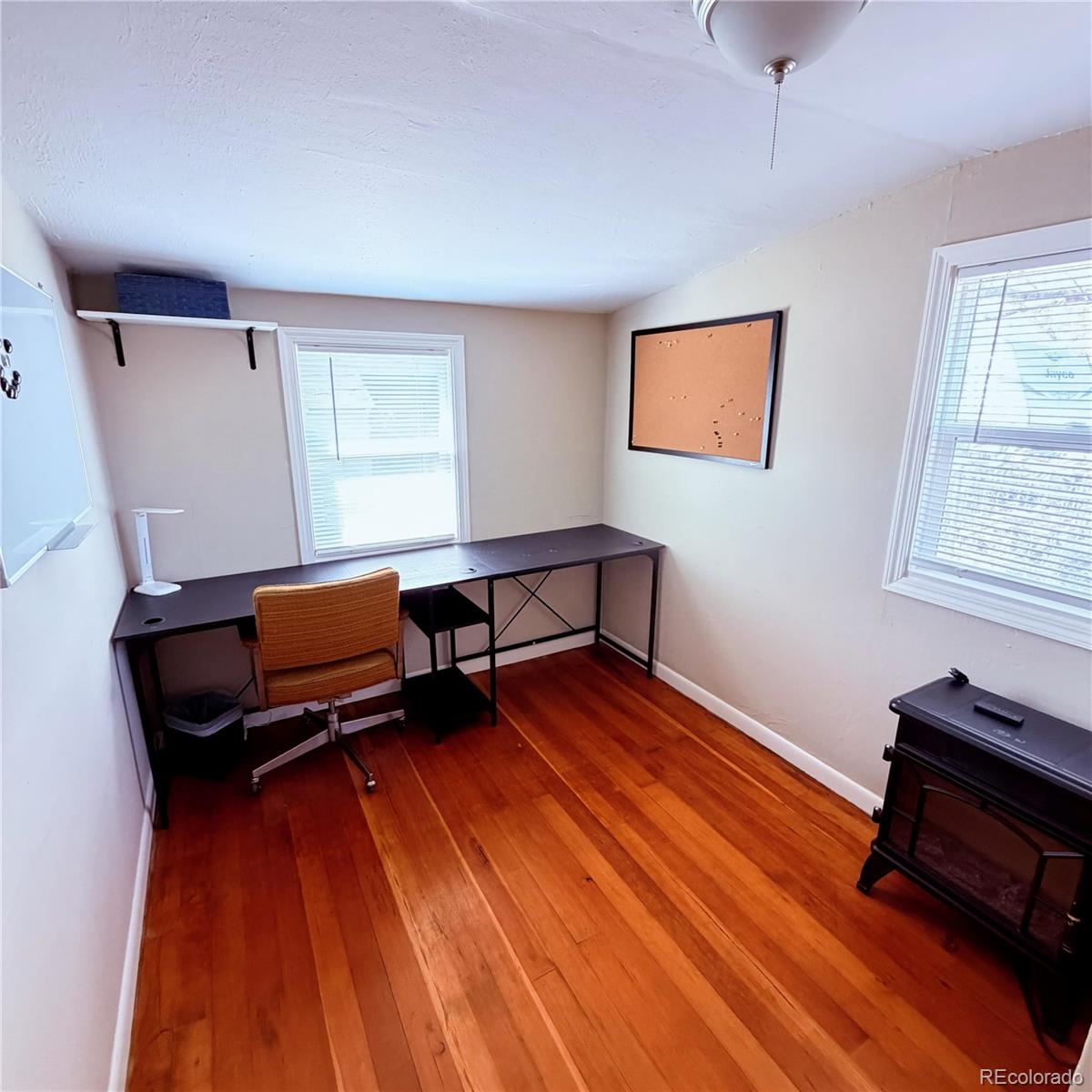 321 Jefferson Street Sterling, CO 80751 - Photo 6 of 10 a living room with a piano and wooden floor