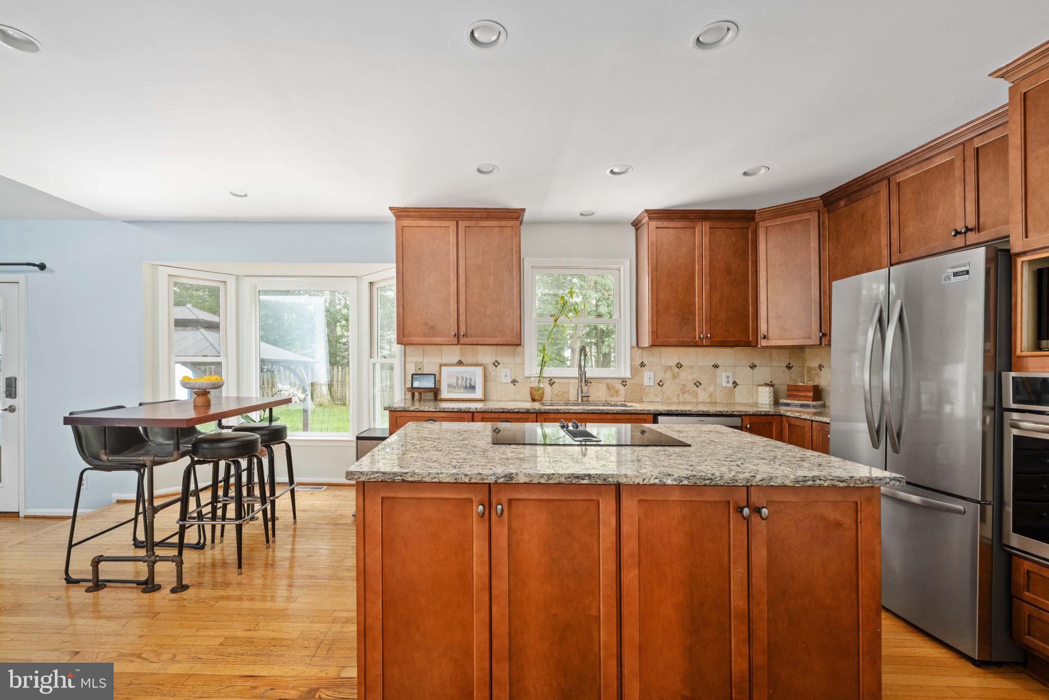 246 Choptank Road Stafford, VA 22556 - Photo 25 of 98 a kitchen with stainless steel appliances granite countertop a refrigerator a stove a dining table and chairs with wooden floor