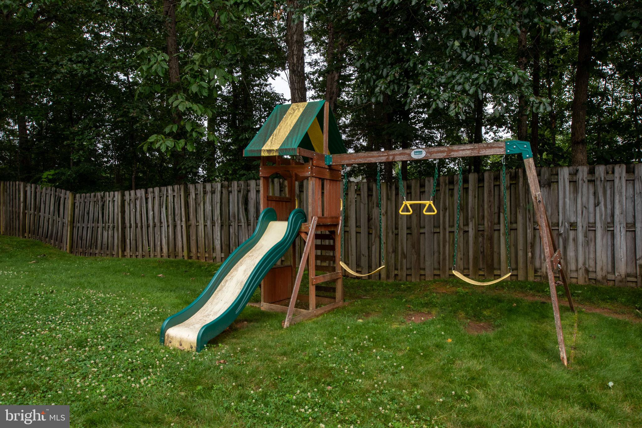 246 Choptank Road Stafford, VA 22556 - Photo 83 of 98 a view of a backyard with a slide and wooden fence