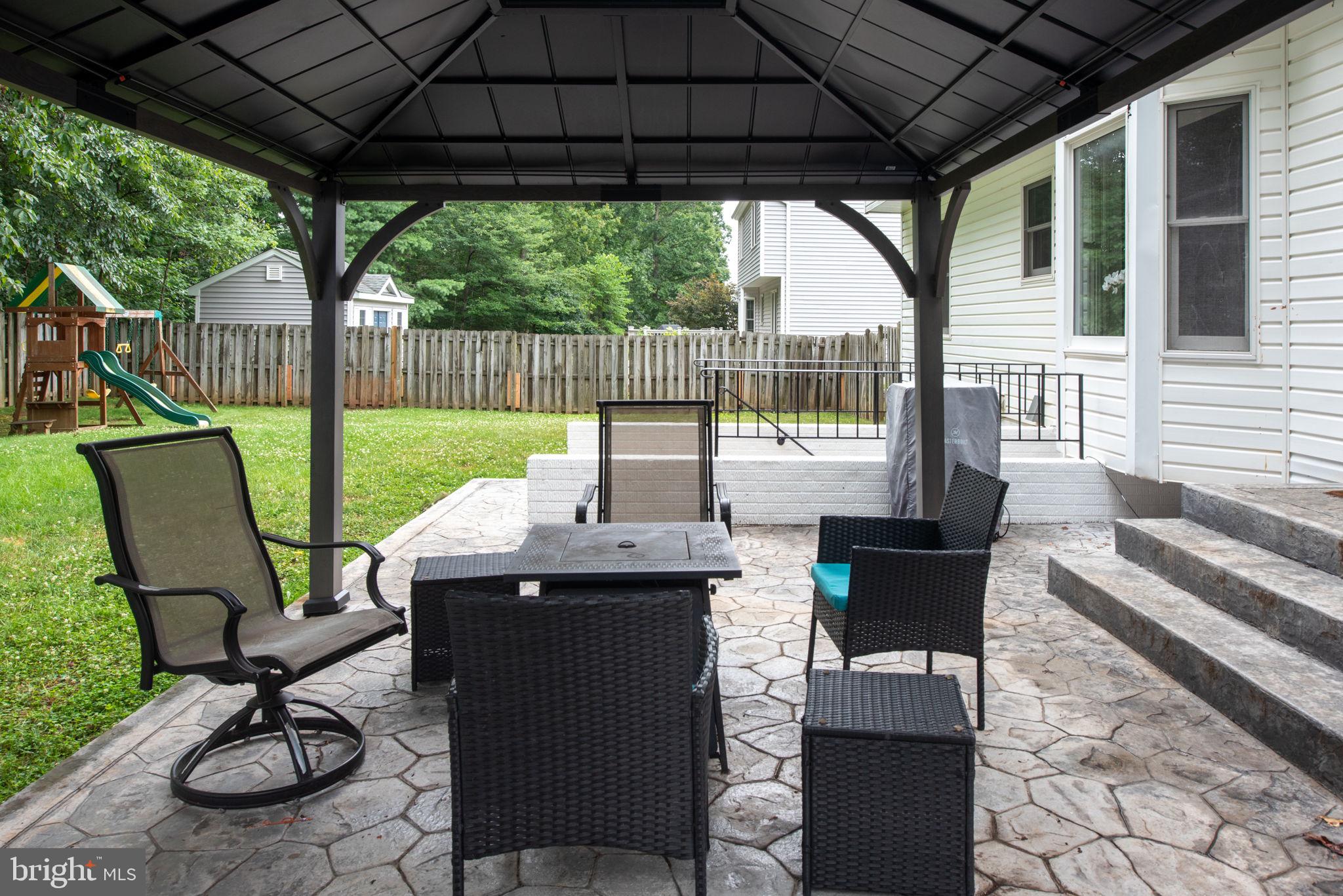 246 Choptank Road Stafford, VA 22556 - Photo 86 of 98 a view of a patio with table and chairs under an umbrella with a small yard