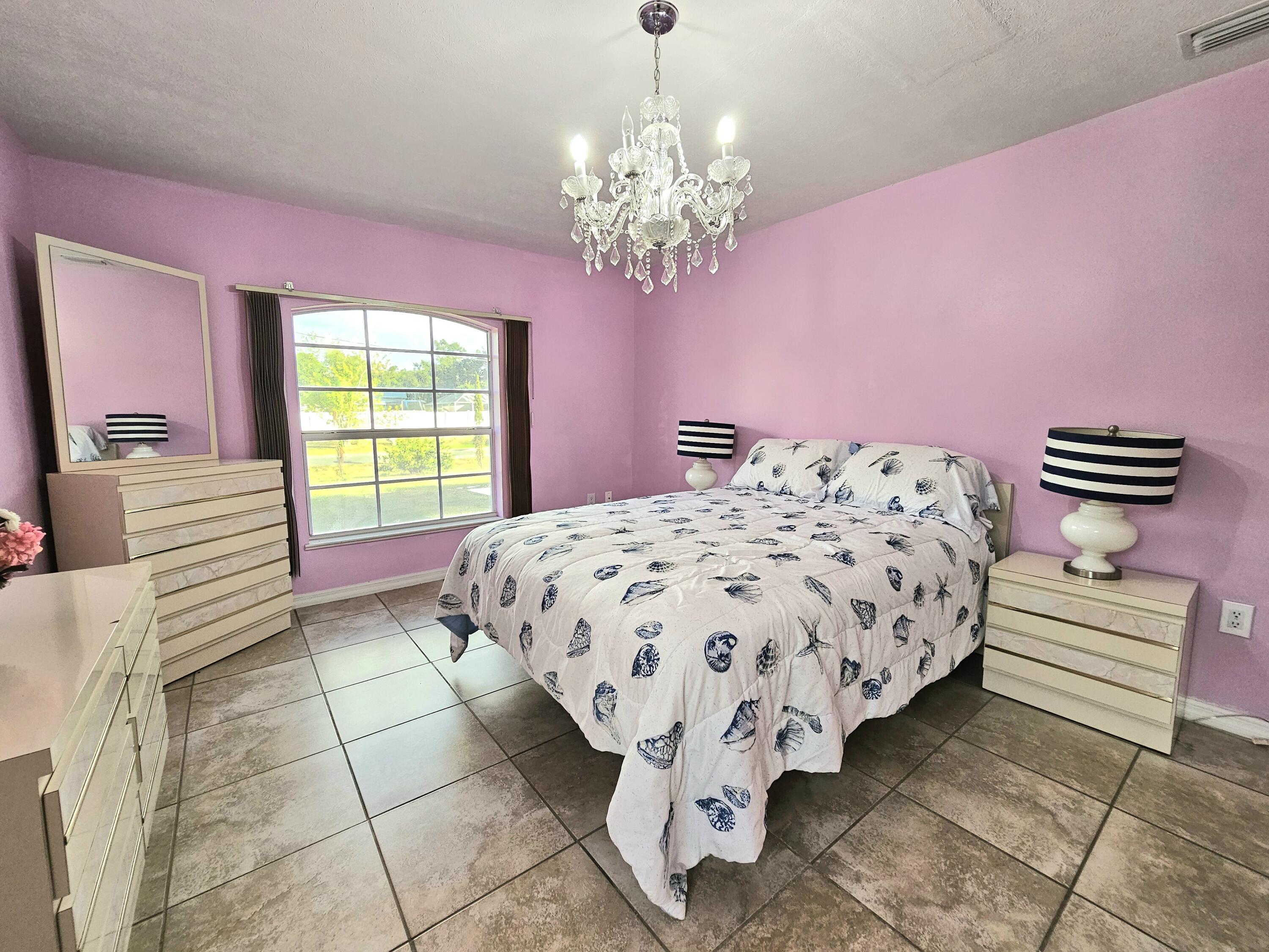 1514 Summer Road Lake Placid, FL 33852 - Photo 25 of 52 a bedroom with a bed and a chandelier