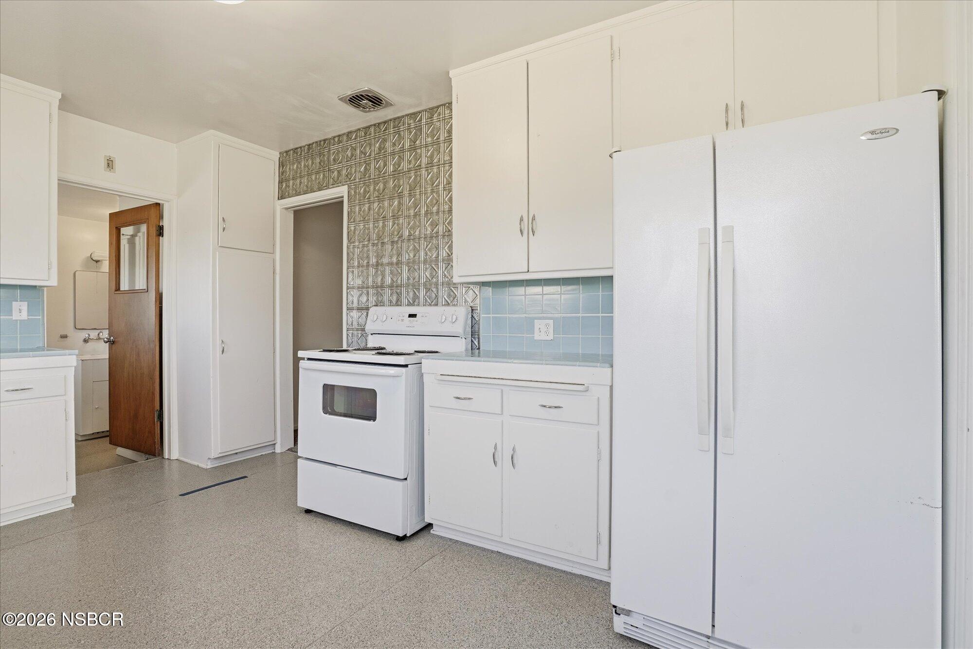 801 East Cook Street Santa Maria, CA 93454 - Photo 4 of 18 a kitchen with white cabinets and white appliances