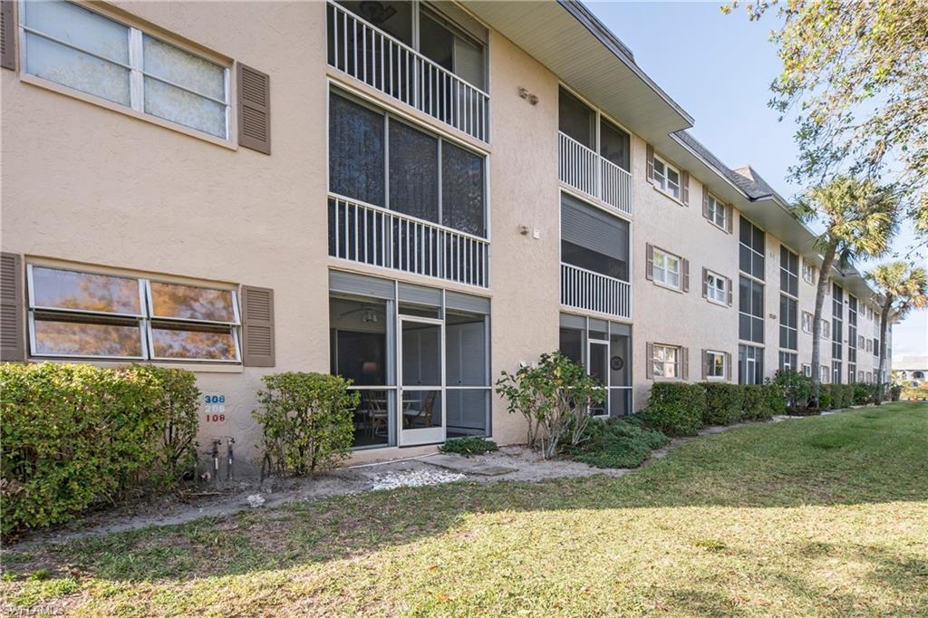 5451 Rattlesnake Hammock Road, Unit D108 Naples, FL 34113 - Photo 14 of 17 a front view of a building with a garden